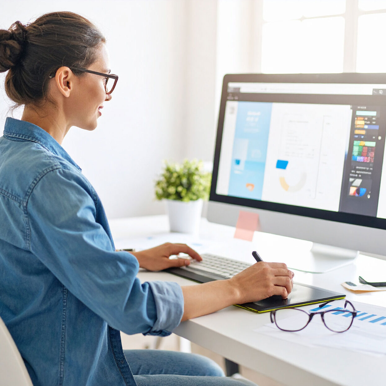 graphic-designer-designing-a-banner-ad-sitting-at-her-computer-desk